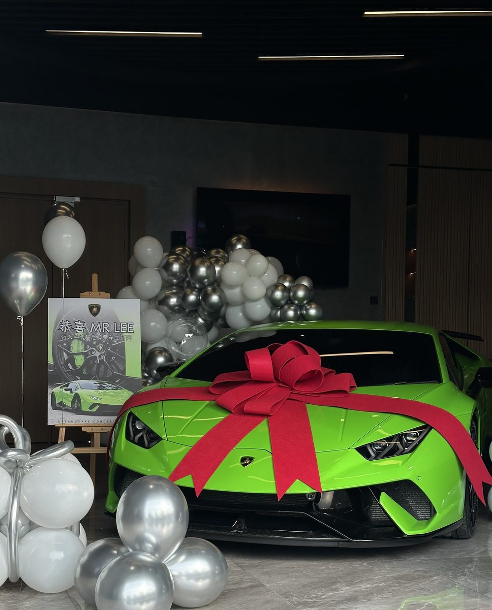 Green Lamborghini Huracán wrapped with a red bow for a client handover