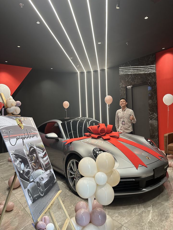 Grey Porsche 911 handover with a red bow